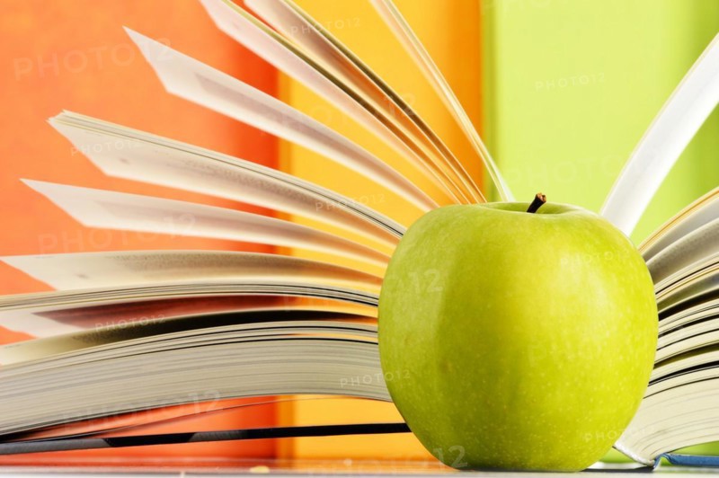 Composition with hardcover books and apple in the library