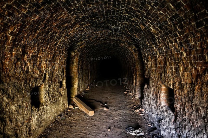 Grunge, spooky arched corridor in an abandoned brick building, urban exploration, haunted tunnel scary looking place