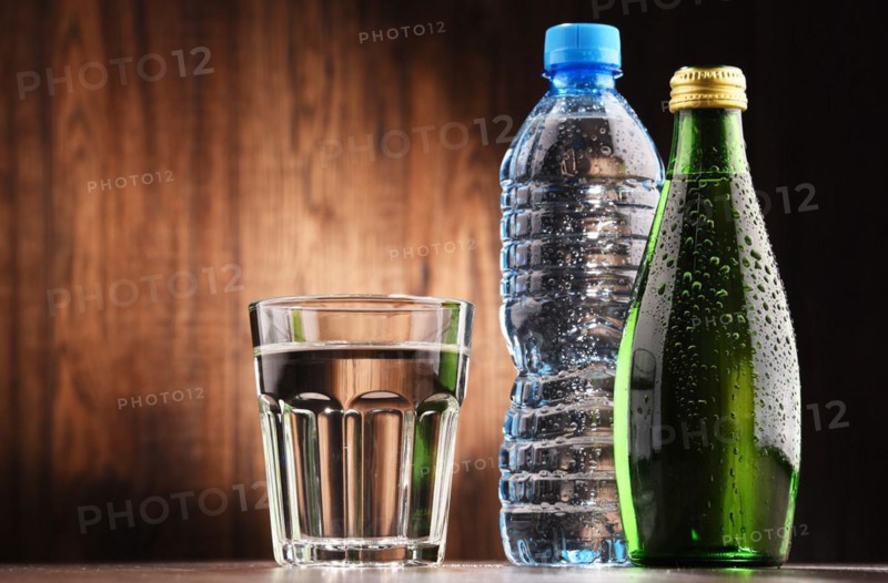 Composition with glass and bottles of mineral water