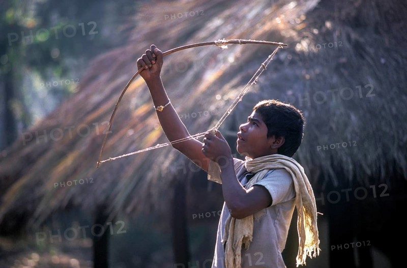 Jenu Kurumba tribal boy aiming with a stone, Nagarahole, Karnataka, South India, India, Asia