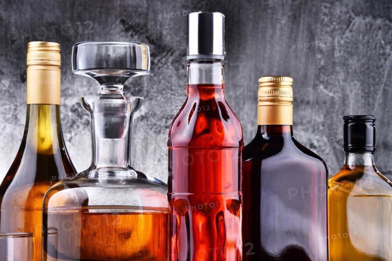 Composition with carafe and bottles of assorted alcoholic beverages