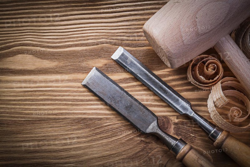Carpenter's chisel and shavings on wooden board