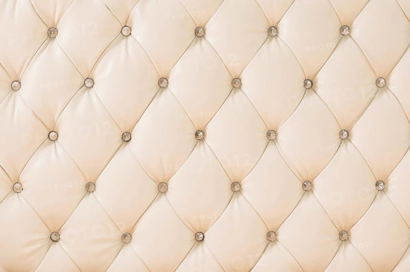 Beige soft tapestry pattern background with symmetrical buttons on the corners of diamonds. Soft and expensive furniture elements. Luxury background