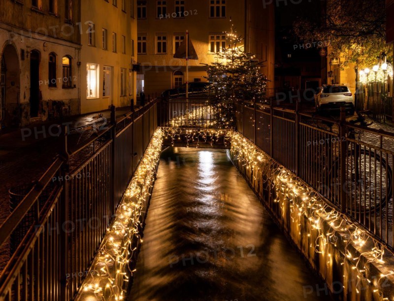 Canal with flowing water in Augsburg decoreated with chrismas lights