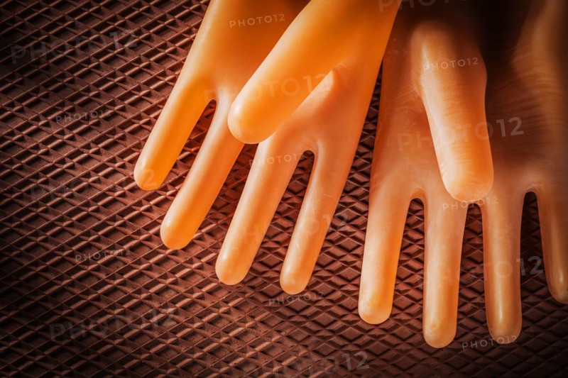 A pair of insulating gloves on a dielectric rubber mat