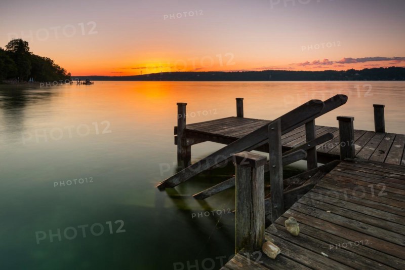 Wooden footbridge at Lake Starnberg near Bernried in Upper Bavaria in summer at sunrise
