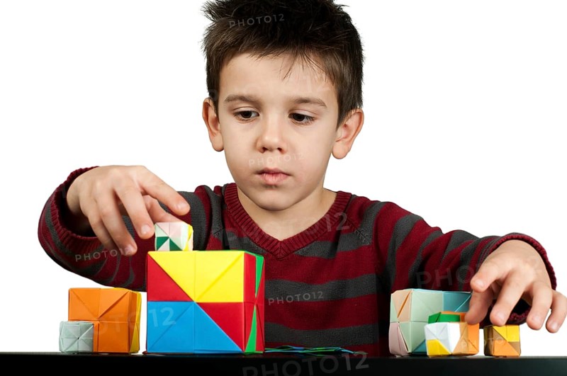 Little boy playing with multicolored cubes