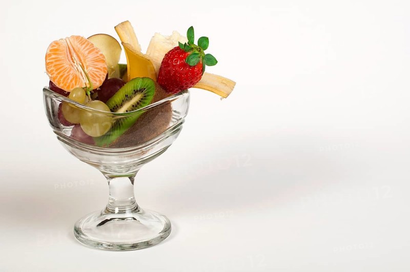 Fruit salad in a glass bowl on white background