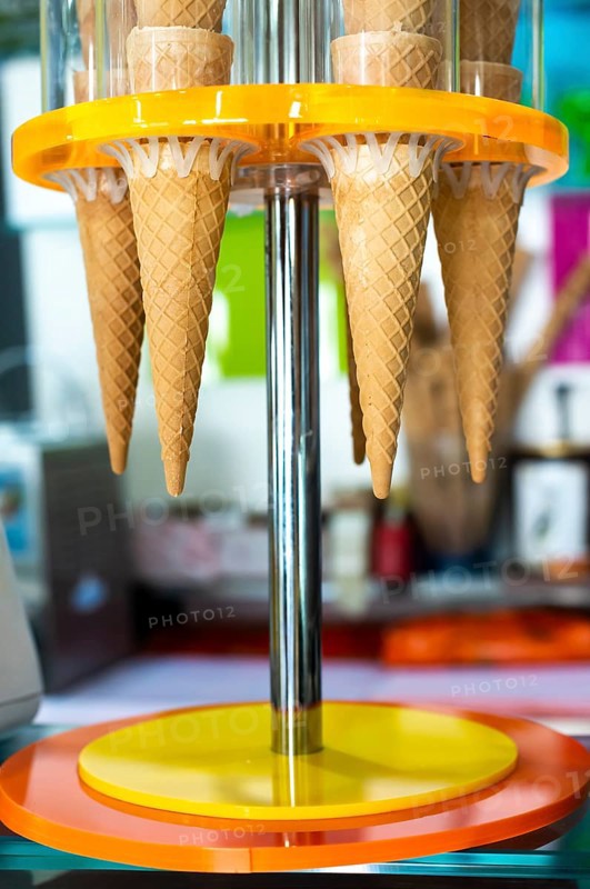 Waffle cones for ice cream put on stand. Ice cream shop. Bright colours. Sweet food