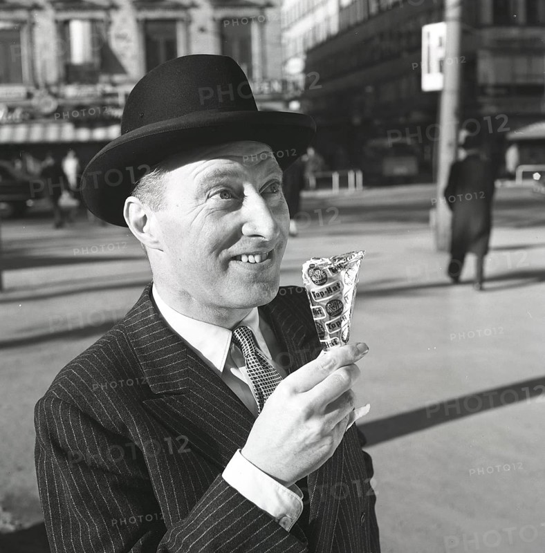 Ice cream in the 1960s. A well dressed gentleman in a suit and hat enjoys a ice cream on a sunny day. Sweden 1965 Kristoffersson ref CN4-6