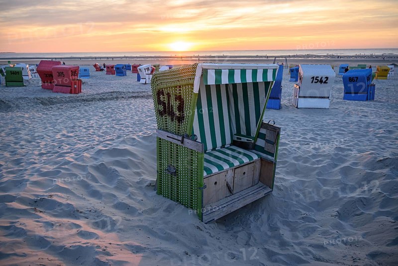 Single green beach chair on the beach at sunset with sea view, langeoog, east frisia, germany
