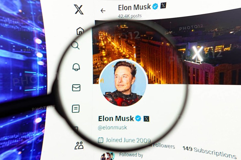 April 17, 2024, Brazil. In this photo illustration, the Elon Musk's official profile, on the social network X (Twitter) logo seen displayed on a computer screen through a magnifying glass