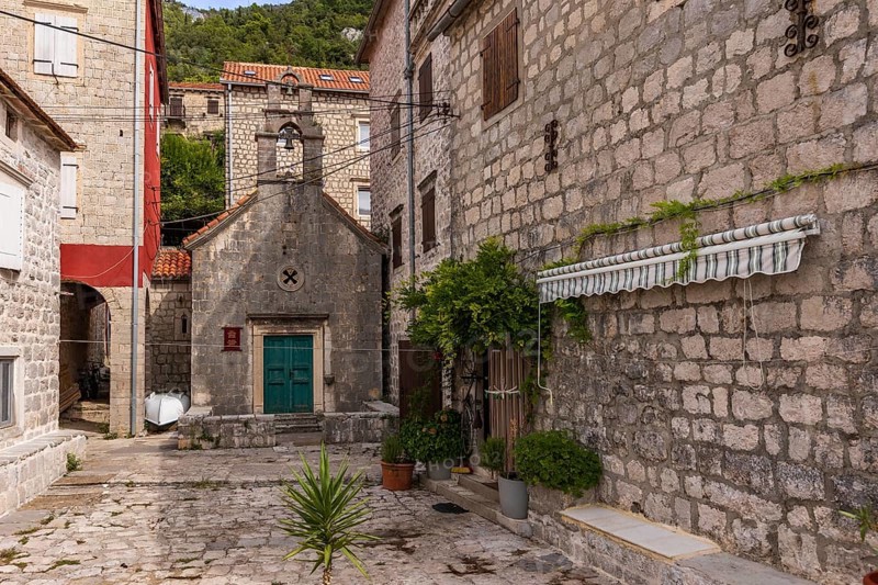 Perast, Montenegro, September 21, 2023: View of the historic town at famous Bay of Kotor with old houses and St. John the Baptist church