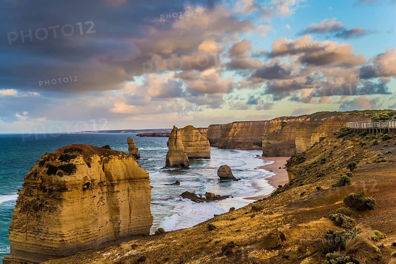 Travel to Australia. Pink dawn clouds over the rocks Twelve Apostles. Early morning on the ocean shore. The concept of active, ecological and photo tourism