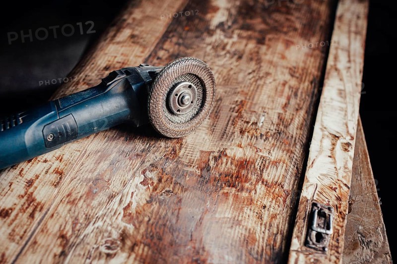 Angle grinder placed on a timeworn wooden board showcasing detailed carpentry
