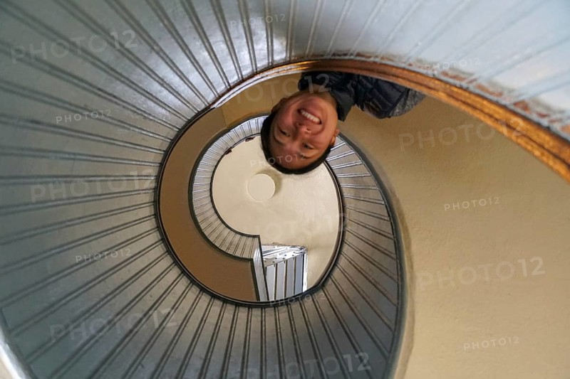 Woman looking down on the top a spiral staircase, circular architectural shape, San Diego, California, USA. November 10th, 2020