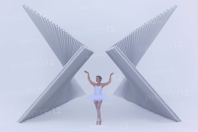 Ballerina poses gracefully between a futuristic sculpture in winter in sub-zero temperatures, Emmendingen, Baden-Württemberg, Germany