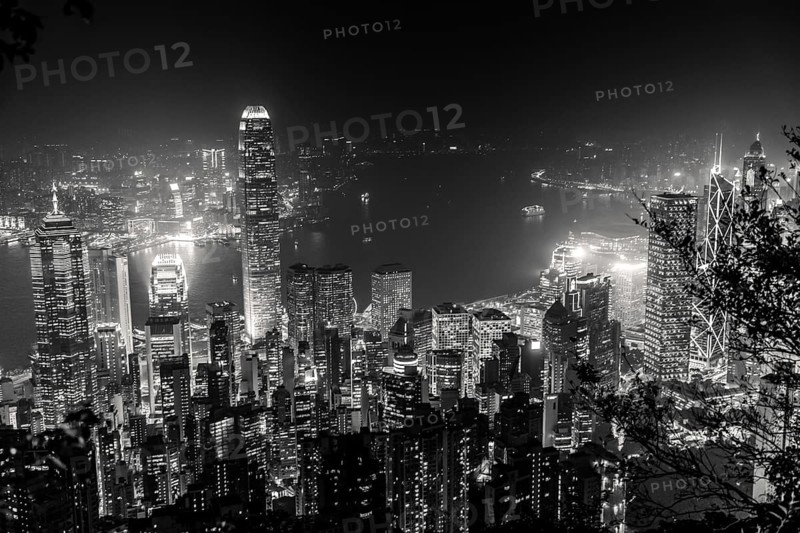 Victoria Harbour skyline by night from Lugard Road Lookout at Victoria Peak, the highest mountain in Hong Kong Island. Panorama of skyscrapers and towers of Hong Kong in black and white
