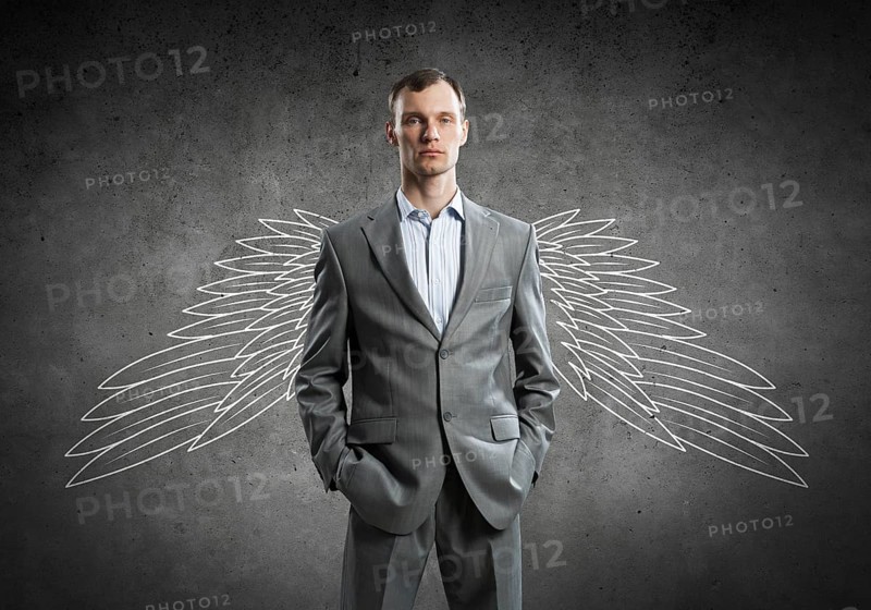 Young businessman with chalk drawn wings behind his back