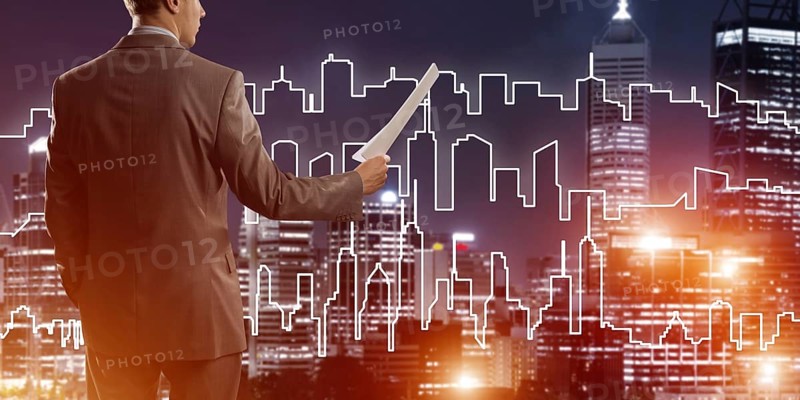 Man architect or engineer presenting construction concept and holding documents in hand