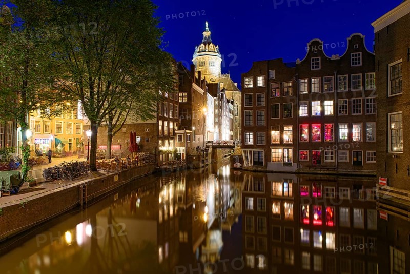 Night view of buildings and boats along the canal in Amsterdam, Netherlands