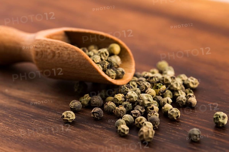 Green Peppercorns on wooden background