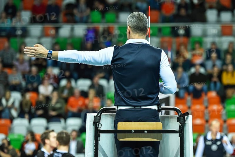Volleyball first referee indicates a point for the team on the left