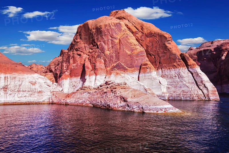 Lake Powell is surrounded by magnificent red hills. Walk on the boat at sunset. Scenic huge artificial water basin of the Colorado River, USA