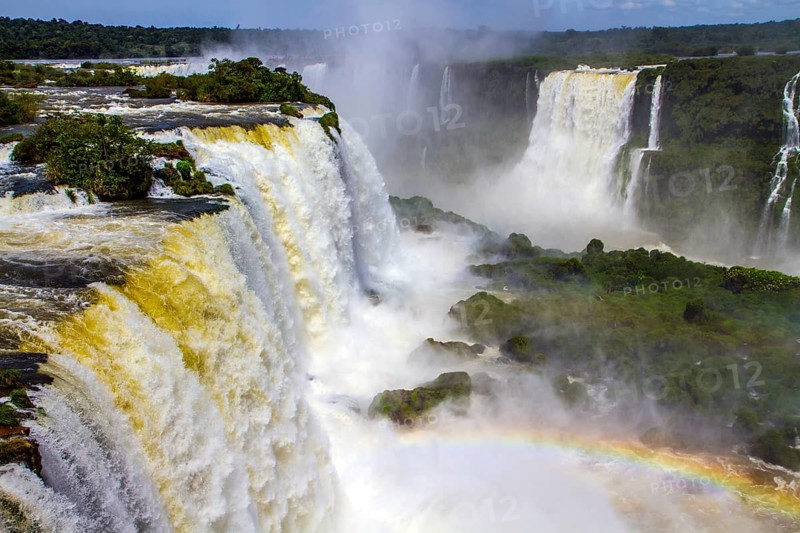 Concept of active and extreme tourism. The fantastic roaring Iguazu Falls in South America, on the border of three countries: Brazil, Argentina and Paraguay