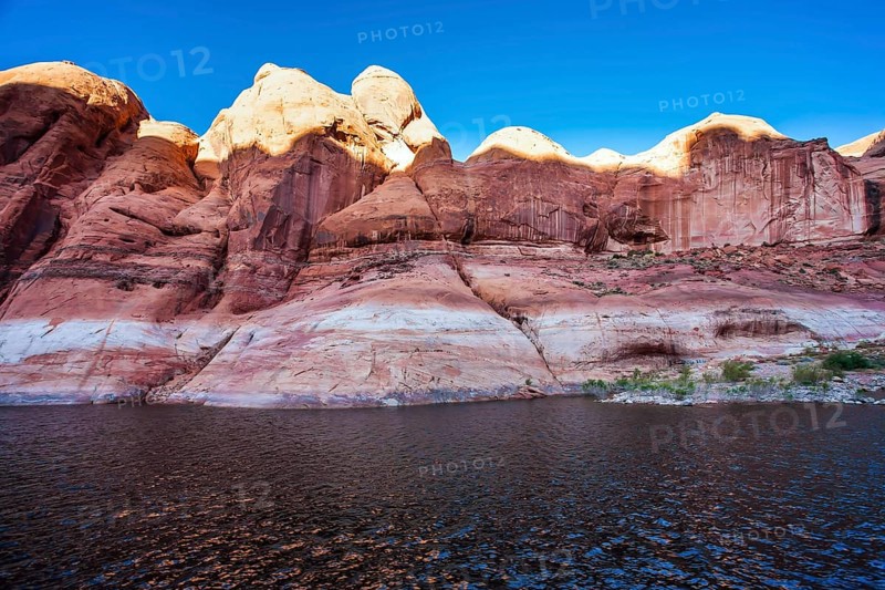 The Colorado River and Antelope Canyon. Grandiose cliffs - red sandstone outcroppings. Tour on a tourist boat on an artificial reservoir Lake Powell. Concept of active and photo tourism