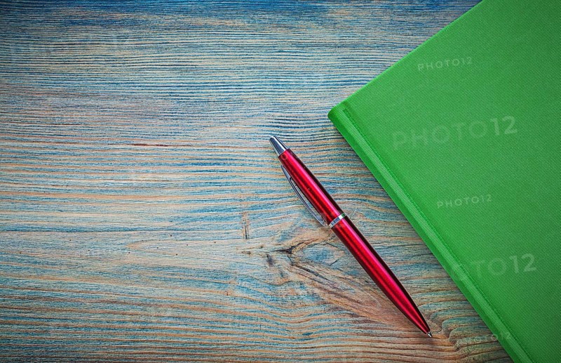 Green notepad pen on vintage wood board copy space education concept