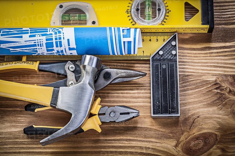 Set of construction tools on wooden board top view