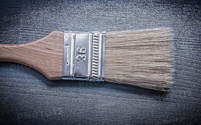 Paintbrush on wooden board close up view construction concept