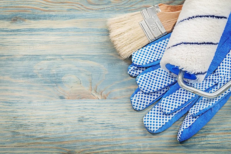 Paint roller brushes protective gloves on wood board construction concept