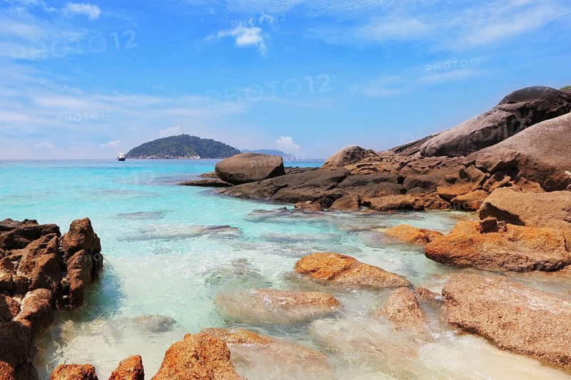 Similansky islands, Andaman Sea, Thailand. The thinnest white sand of a beach adjoins with huge brown rocks and azure water