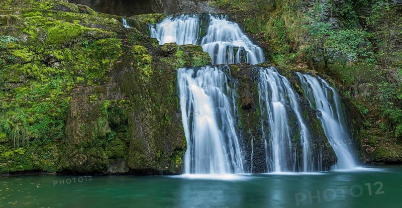 Waterfall from the source of the Lison in a haven of peace with its waterfall surrounded by forest. Banner. Nans-sous-Sainte-Anne, Doubs, Bourgogne-Franche-Comte, France