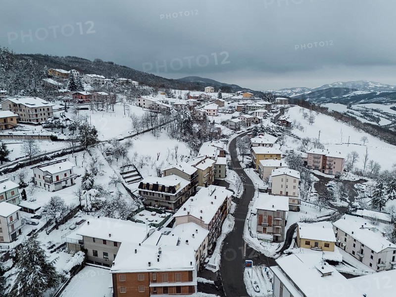 Aerial view of bore, a village in the province of parma covered by snow in december 2024, showcasing the winter landscape of the italian apennines