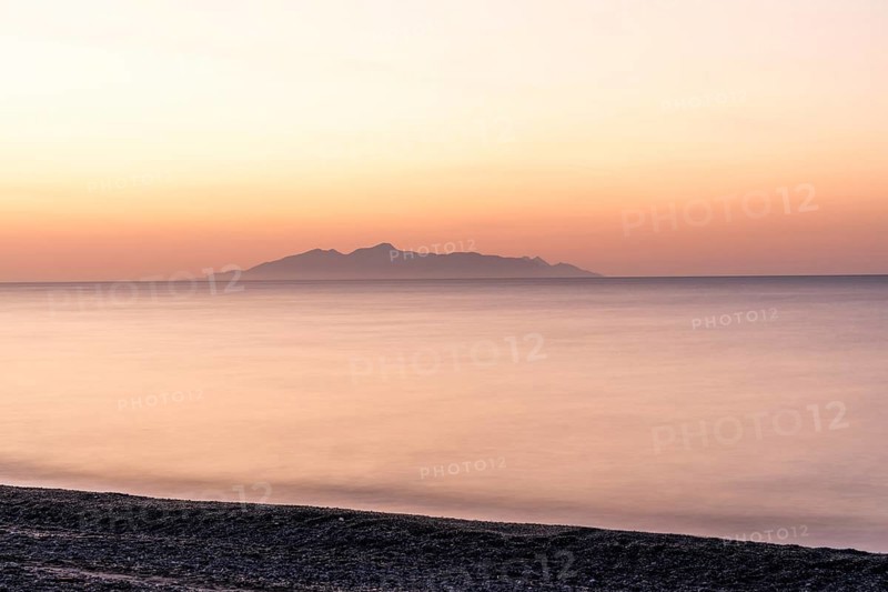 Dawn at sunrise, view from the lava beach near Kamari to the island of Anafi, long exposure, island of Santorini (Thira), Cyclades, Greek Islands, Greece