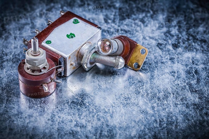 Electric toggle switch lamp-holder on metallic surface electricity concept