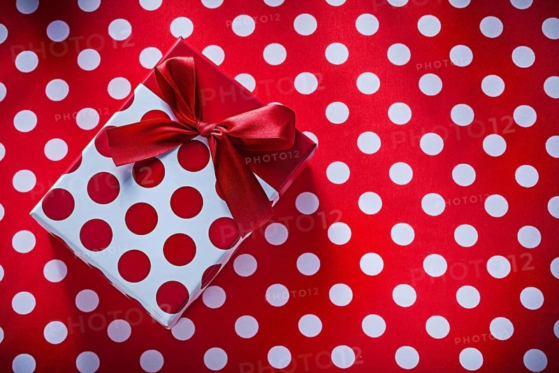 Wrapped box with present on polka-dot fabric celebrations concept