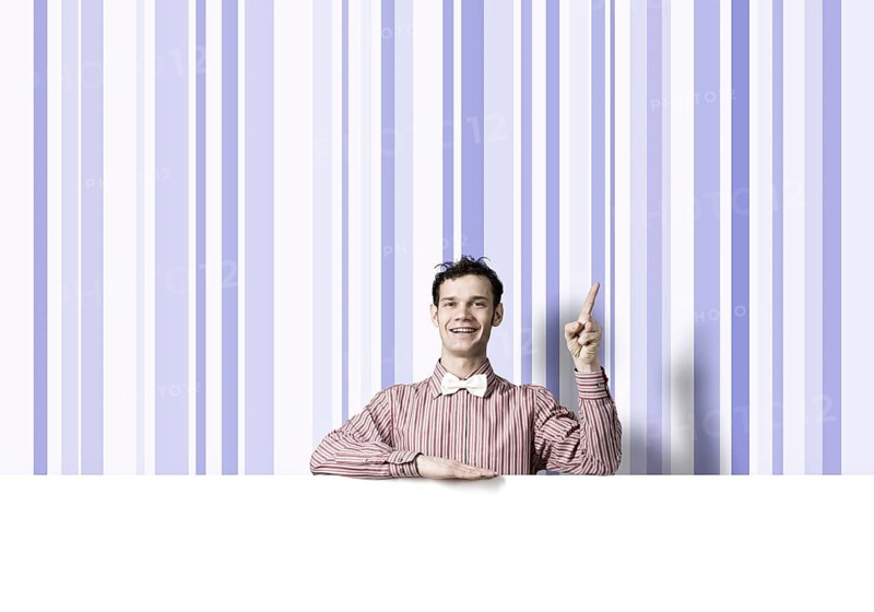 Young funny guy in checked shirt with banner pointing with finger up