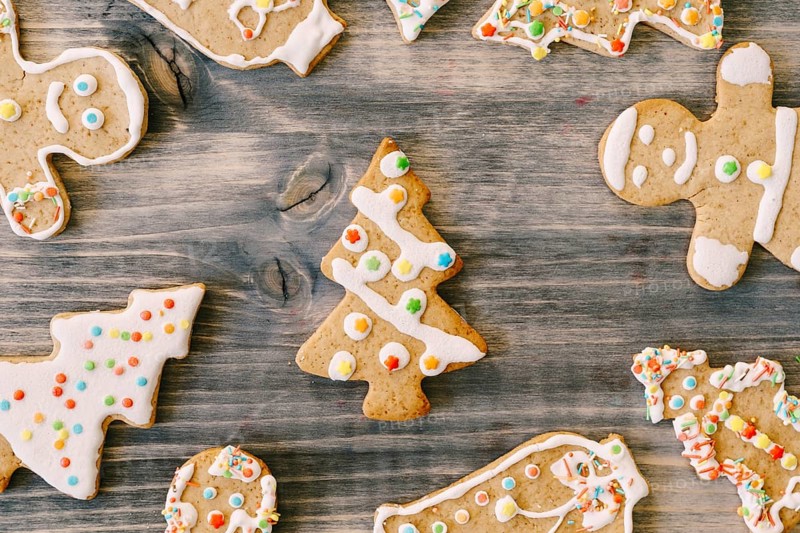 Colorful Christmas gingerbreads in the shape of Christmas trees and little men decorated with color icing.