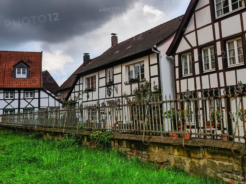Large half-timbered houses with a fenced garden and clouds in the sky, Herten, North Rhine-Westphalia, Germany