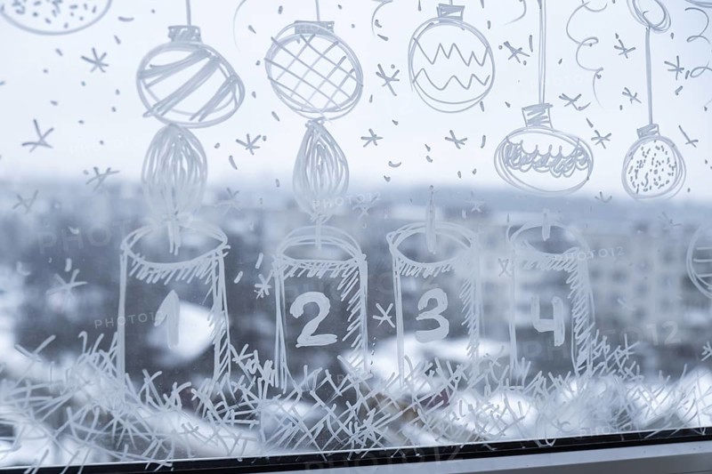 Sustainable responsible holiday decor. Christmas advent candle painted on window glass indoor at home. Christmas winter decoration. White pattern. Snow art tracery on season. Diy. Hygge home