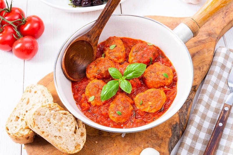 Baked mini meatballs in tomato sauce with basil