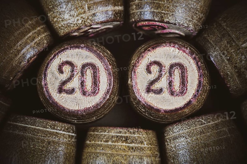 Vintage wooden lotto kegs two numbers 20 and 20 as symbol of 2020 year. Close-up top view of 2020 New Year inscription in circle. Vignette, trendy brown toning, vintage instant color photo effect