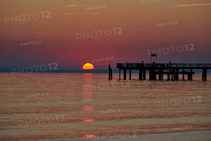 Sunrise over the sea at the pier of the Baltic Sea resort, Boltenhagen, Mecklenburg-Vorpommern, Germany