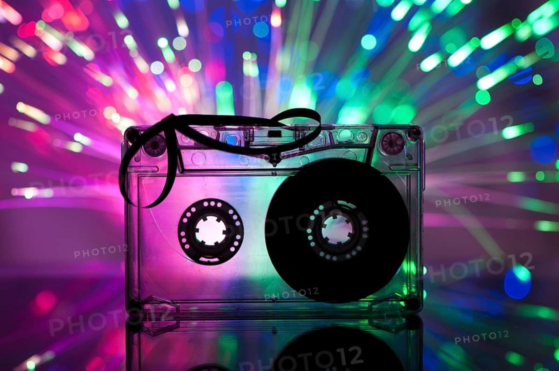 Cassette tape and multicolored pink blue lights on background