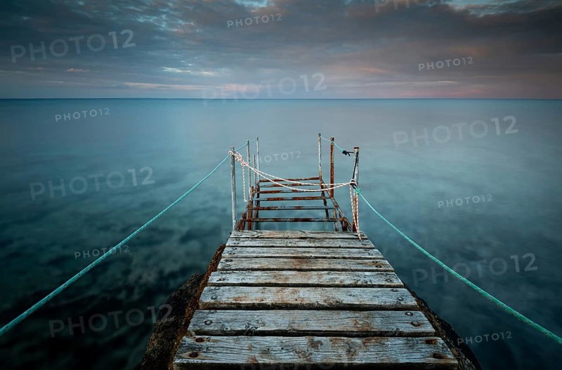 Long wooden pier in the sea at sunset. Protaras Cyprus