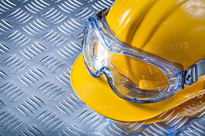 Protective glasses building helmet on grooved metal sheet construction concept